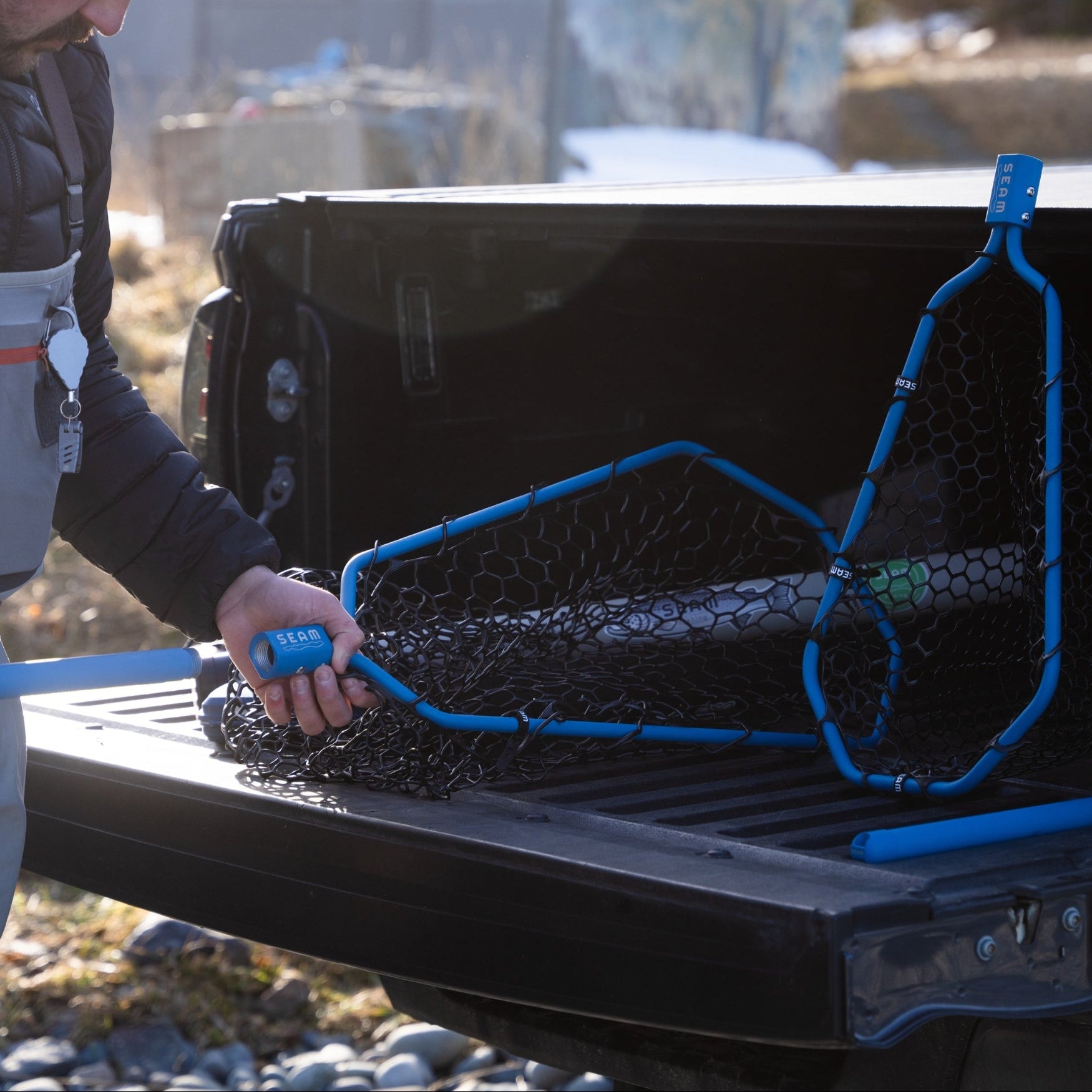 Person swapping handles on a fishing net in the back of a truck