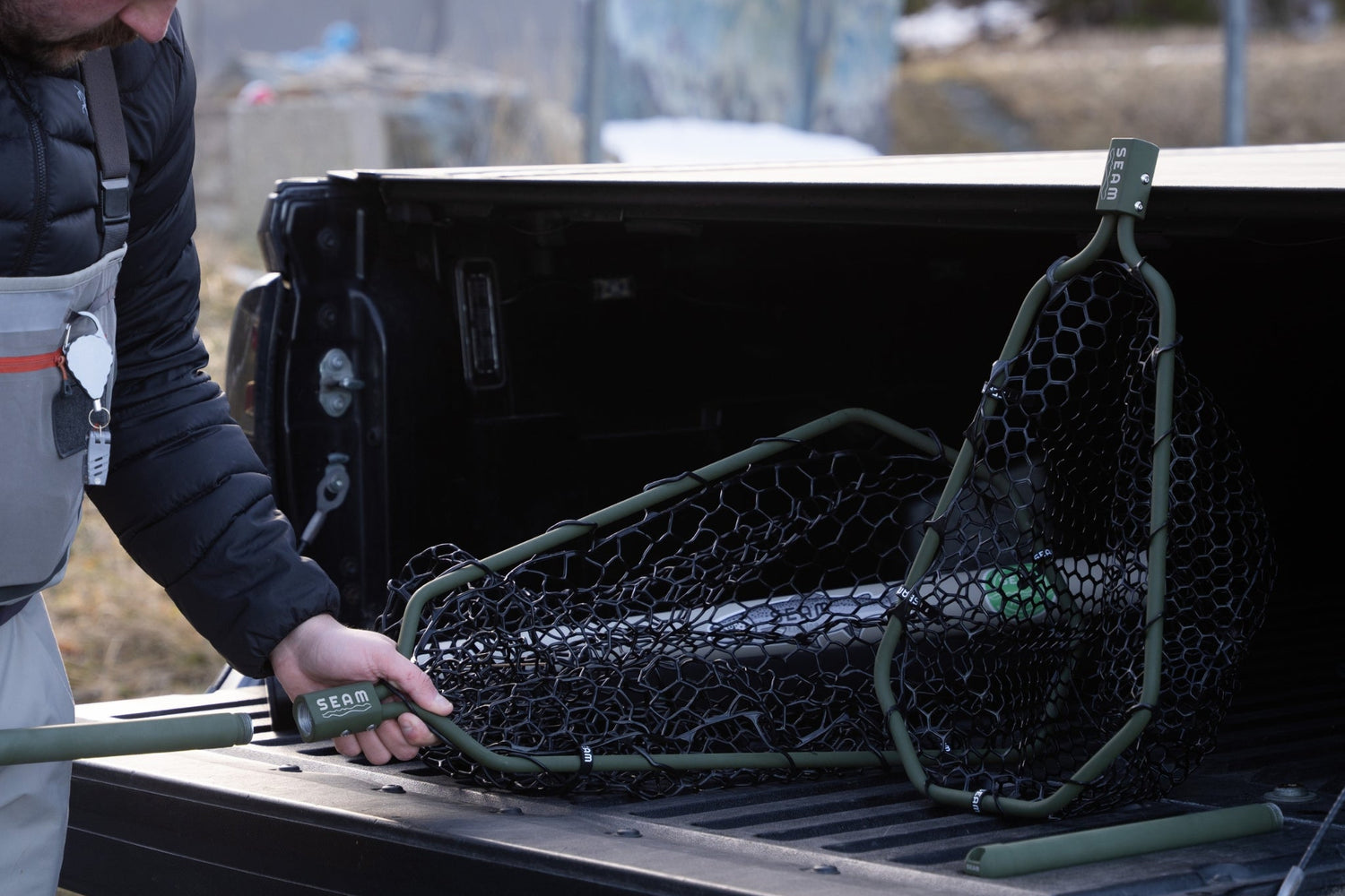 Person loading a fishing net into the back of a truck