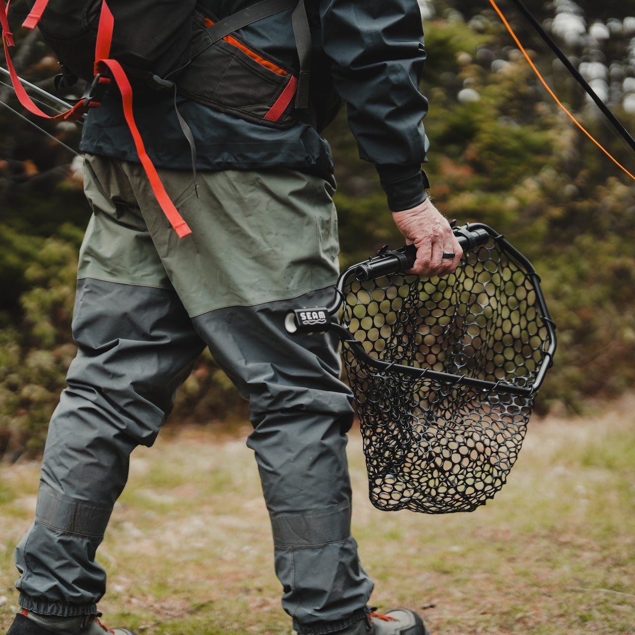 Hiking with a collapsible landing net going fishing